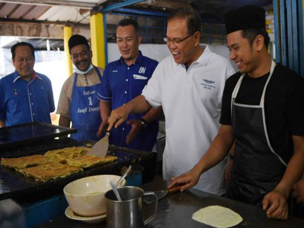 Wan Rosdy (dua dari kanan) bersama calon BN, Mohd Sharim Md Zin (tengah) beramah mesra dengan peniaga roti, Muhammad Dzul Arfandi Zaidi, 29, ketika bersarapan di kedai makan Dee Ikram Jaya Felda Chini Timur Tiga sempena kempen PRK DUN Chini hari ini. - Foto Bernama