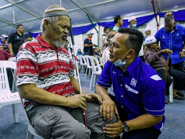 Mohd Sharim beramah mesra bersama veteran ATM, Ahmad Abu, 61, pada majlis jejak veteran dan lawatan kebajikan Menteri Kanan Pertahanan bersama veteran ATM Felda Chini di Pusat Bandar Dara Felda Chini semalam. - Foto Bernama