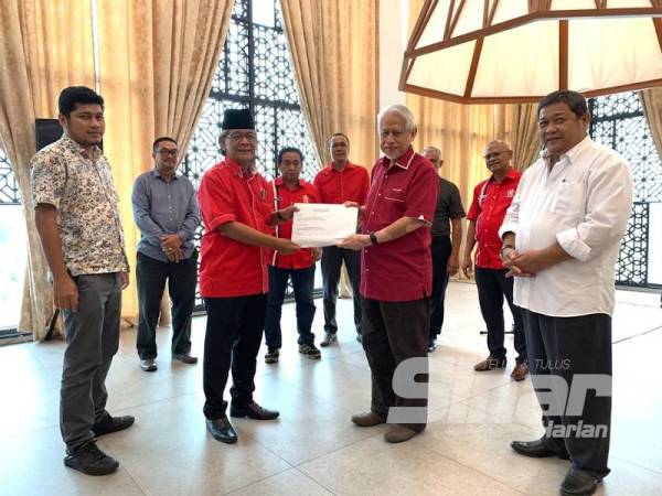 Kamarudin (kanan) menerima surat lafaz ikrar sokongan terhadap Perdana Menteri dari bahagian Machang yang diserahkan oleh Kamaruddin.