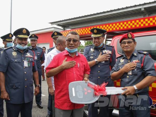 Ismail (dua dari kiri) menyerahkan replika kunci kepada Mohd Fadzilah ketika mengadakan lawatan kerja ke Balai Bomba dan Penyelamat Chini, hari ini.