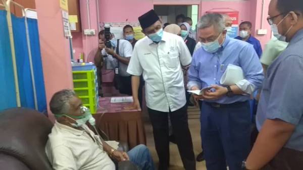 Dr Adham (dua dari kanan) menyantuni seorang pesakit yang mendapatkan rawatan di Klinik Kesihatan Chini.