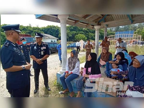 Hasanuddin (kiri) bertanya khabar ahli keluarga yang masih menunggu perkembangan terkini berkaitan empat lagi mangsa belum ditemui.