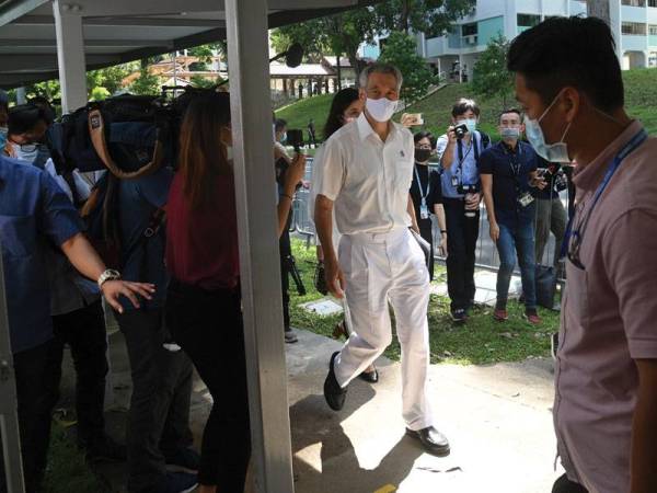 Hsien Loong (tengah) tiba di pusat penamaan calon bagi mengemukakan kertas pencalonan beliau untuk bertanding di GRC Ang Mo Kio. - Foto AFP