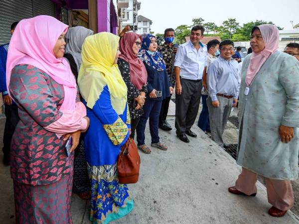 Zuraida (kanan) beramah mesra dengan tetamu pada majlis perasmian Pejabat Penggerak Dasar Komuniti Negara Parlimen Hang Tuah Jaya, Bachang hari ini. 