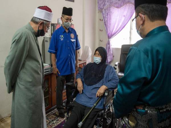 Dr Zulkifli Mohamad Al-Bakri beramah mesra bersama penerima bantuan Menah Ali, 67, sempena Misi Musa'adah Pasca Covid-19 JAWI Food Bank di Madrasah Babul Khairat, Projek Perumahan Rakyat (PPR) Perkasa, Cochrane hari ini. - Foto Bernama