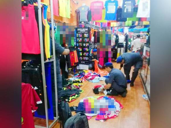 Penguat kuasa KPDNHEP sedang melakukan operasi ke atas premis yang dikesan menjual jersi tiruan.