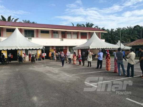 Pengundi mematuhi garis panduan ditetapkan dengan melaksanakan penjarakkan sosial ketika beratur di salah satu saluran mengundi di Sekolah Agama Rakyat, Kelas Fardu Ain (SAR/KAFA) Felda Chini 3 di sini pagi ini.