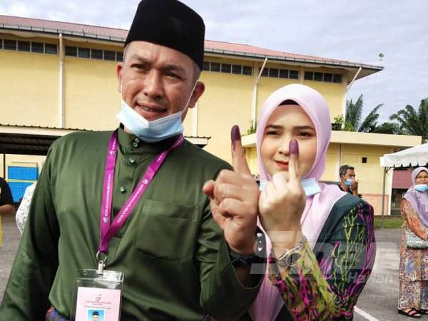 Mohd Sharim dan isteri tiba di pusat pengundian di Sekolah Agama Rakyat, Kelas Fardu Ain Felda Chini 3 di sini pagi tadi.