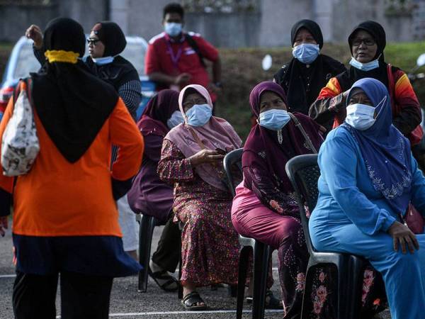 Para pengundi menunggu giliran mengundi Pusat Mengundi di Kelas Al-Quran dan Fardu Ain (KAFA) Felda Chini 3 di sini hari ini.  - Foto Bernama