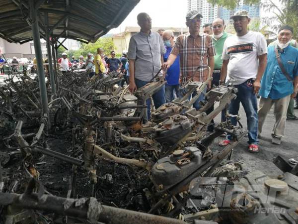 Hassan (kanan) bersama Shafie (tengah) meninjau kawasan garaj motosikal yang musnah dalam kebakaran di PPR Gombak Setia, Setapak di sini awal pagi tadi.