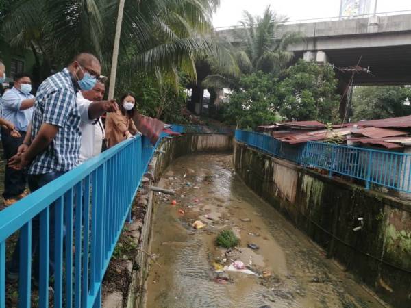 Hannah (kanan) turun padang bagi melihat pemasangan pengadang besi yang selesai dipasang di bawah peruntukan DBKL hari ini.