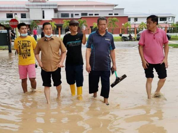 Jeck Seng (dua dari kiri) meninjau keadaan banjir di Pekan Nanas yang berlaku pada bulan lalu.