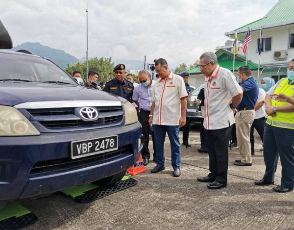 Shaharuddin (kiri) melihat penggunaan alat timbang mudah alih yang diterima JPJ untuk digunakan UPLR. 