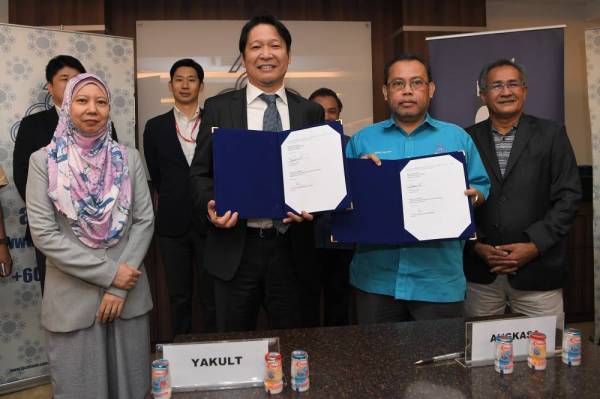 Abdul Fattah Abdullah (dua, kanan) bertukar dokumen dengan Pengarah Urusan Yakult (Malaysia) Sdn Bhd Hiroshi Hamada (dua, kiri) pada Majlis Menandatangani MoU antara Angkasa dan Yakult (Malaysia) Sdn Bhd di Angkasa hari ini. -Foto Bernama