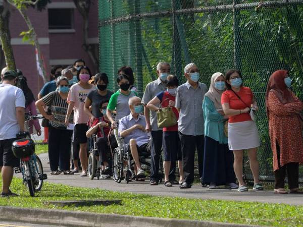 Kumpulan pengundi yang terpaksa beratur panjang menunggu giliran untuk menunaikan tanggungjawab mereka. - Foto: AFP