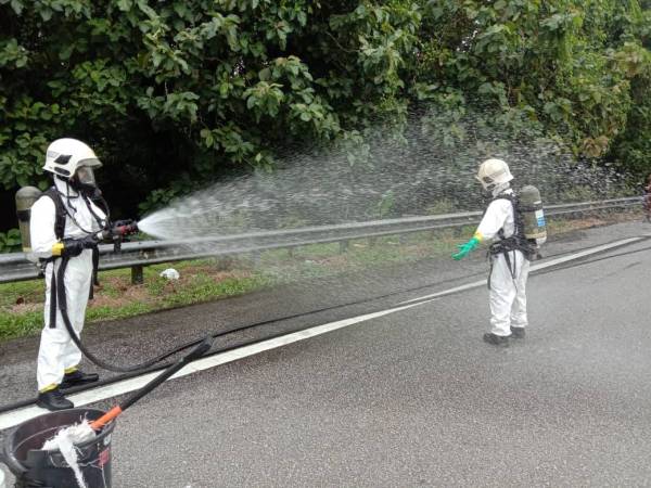 Anggota bomba membersihkan tumpahan bahan kimia di Kilometer 353 Lebuhraya Utara Selatan (arah utara), berhampiran Bidor hari ini. 