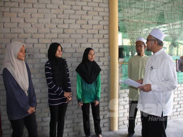 Razman (kanan) ketika mengadakan kunjungan ke rumah sewa didiami empat beradik yatim piatu di Taman Serai Permai, Bagan Serai kelmarin. 