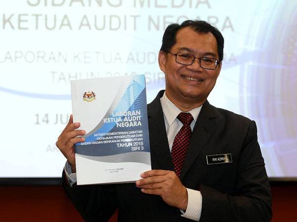 Ketua Audit Negara Datuk Nik Azman Nik Abdul Majid menunjukkan laporan Audit Negara pada sidang media Laporan Aktiviti Kementerian/Jabatan Kerajaan Persekutuan dan Badan-Badan Berkanun Persekutuan tahun 2018 Siri Tiga dan Laporan Aktiviti Jabatan/Agensi dan Pengurusan Syarikat Kerajaan Negeri Tahun 2018 Siri Tiga hari ini. - Foto Bernama