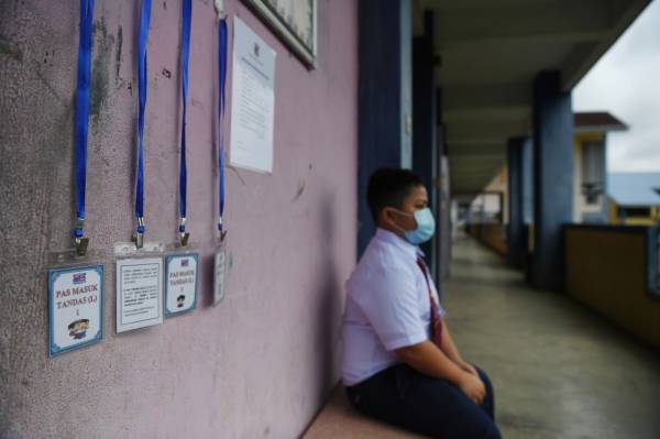 Murid tahun enam Sekolah Kebangsaan Teruntum Muhammad Hadeeb Fareesh Amran,12, memakai pelitup muka ketika menunggu giliran untuk menggunakan tandas. -Foto Bernama