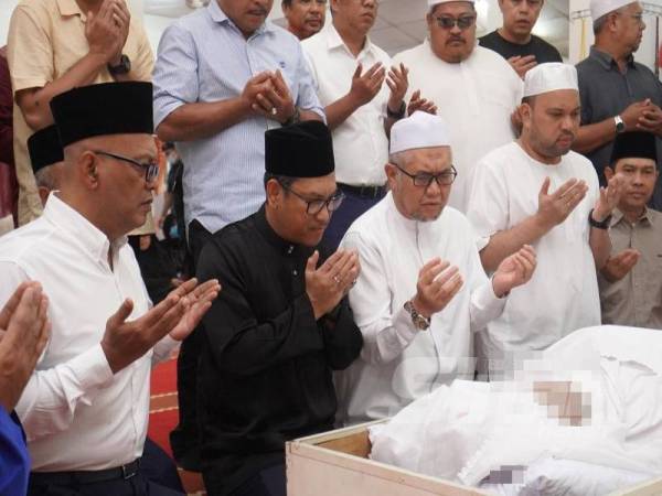 Ahmad Faizal (duduk, dua dari kiri) mengaminkan doa yang dibacakan Razman (duduk, tengah) ketika menziarahi Allahyarham Mohd Khusairi di Masjid Al-Rahmaniah Felda Sungai Behrang di sini.