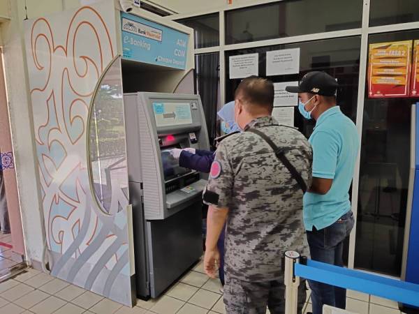 Salah seorang tertuduh (kanan) membayar denda di Mahkamah Sesyen, Kuala Terengganu hari ini.