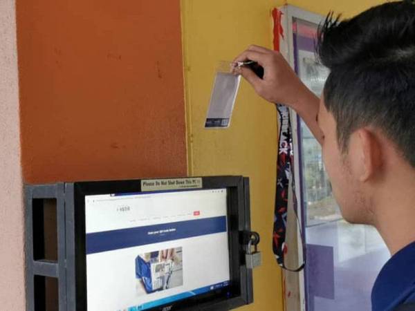 Pelajar SMK Rasau Kerteh B5 menggunakan sistem i-Hadir dengan mengimbas kad bagi merekodkan kehadiran.