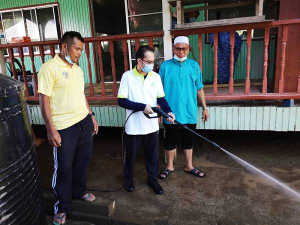 Mustakim Mohamad (tengah) ketika turut sama bergotong-royong membersihkan Masjid Jamek Al-Hashim, Kota Belud, semalam.