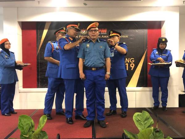 Pemakaian pangkat dan watikah pelantikan pegawai APM Mejar Bersekutu, Datuk Mohd Azizi Abu Naim (tengah) yang disempurnakan Mohd Redzuan (tiga dari kiri).