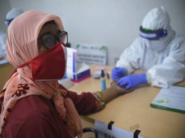 Kakitangan perubatan mengambil sampel darah dari seorang wanita untuk ujian Covid-19 di Jakarta, Indonesia. Foto: Xinhua