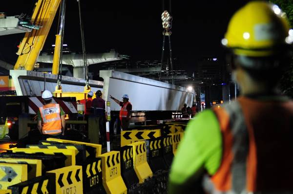 Kerja-kerja manaikan U-Girder dilakukan secara berhati-hati menggunakan kren pada Majlis Pelancaran U-Girder Projek Transit Aliran Ringan 3 (LRT3) di tapak projek LRT3, Seksyen U1, malam tadi. - Foto Bernama