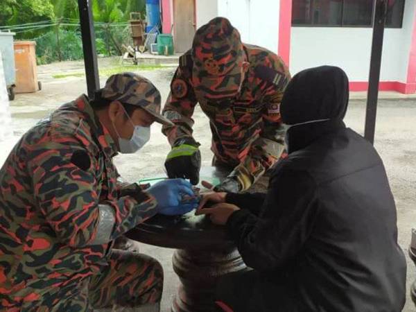 Anggota bomba membantu memotong cincin yang tersekat di jari manis seorang wanita di BBP Muar, Johor hari ini.