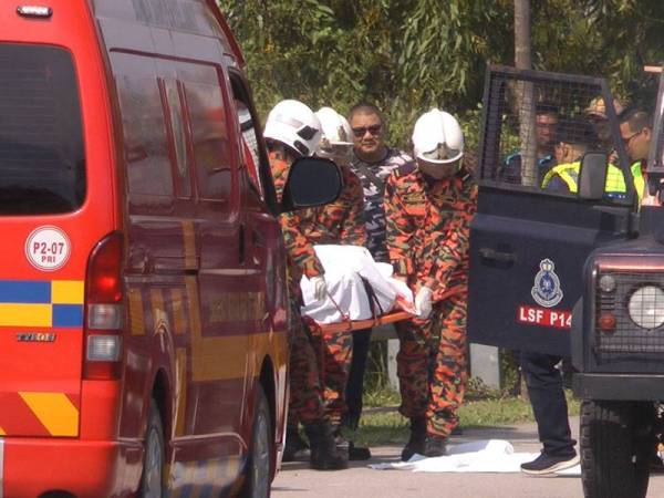 Anggota bomba mengangkat keluar mayat mangsa yang ditemukan di dalam parit.