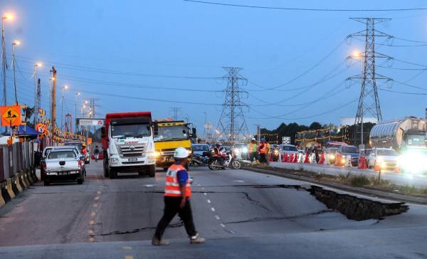 Keadaan jalan raya yang mendap seluas kira-kira 30 meter persegi berlaku di Jalan Klang-Banting berhampiran lampu isyarat Kampung Johan Setia menghala ke Banting. - Foto Bernama