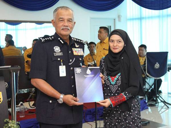 Zainuddin menyampaikan sijil penghargaan Ketua Polis Kedah kepada Ketua Wartawan Sinar Harian Utara, Roslinda Hashim.