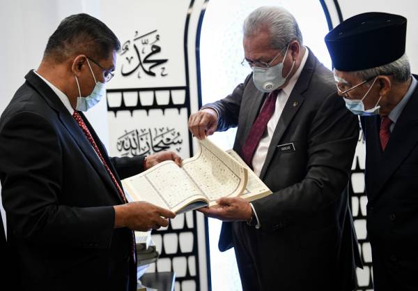 Annuar Musa (dua, kanan) menyerahkan Al-Quran Mushaf Putrajaya kepada Takiyuddin Hassan (kiri) pada majlis penyerahan Al- Quran Mushaf Putrajaya kepada surau utama bangunan parlimen di Bangunan Parlimen hari ini. -Foto Bernama