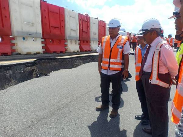 Tajuddin (kanan) ketika meninjau keadaan lokasi jalan mendap di Jalan Klang - Banting hari ini.