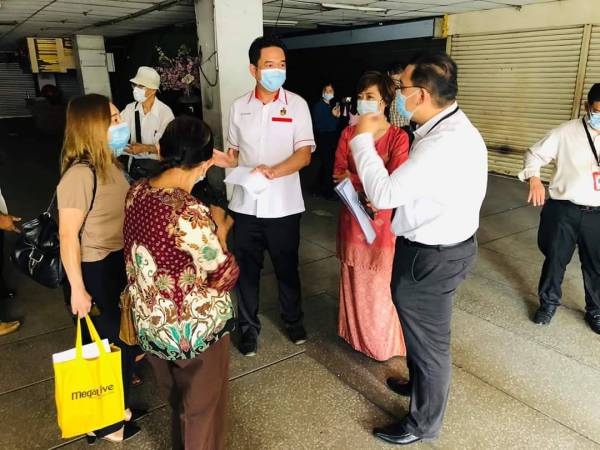 Teo Kok Seong (tiga dari kanan) dan Nicole (dua dari kanan) berbincang dengan pemilik lot kedai di Wisma Punca Emas.