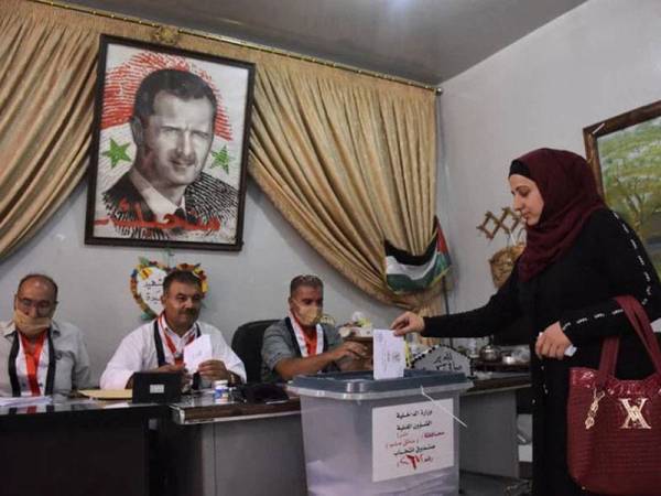 Seorang wanita mengundi pada pilihan raya Parlimen di kawasan kejiranan Nubl, Aleppo pada 19 Julai lalu. Potret Presiden Syria, Bashar Al-Assad diletakkan pada dinding berhampiran peti undi. - Foto AFP