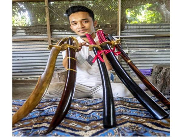 Saiful Azhar menunjukkan sebahagian jenis pedang yang dihasilkan seperti Buaya Berenang, Pedang Melayu dan Samurai ketika ditemui di bengkelnya di Kampung Jejulok dekat Slow Machang di sini. - Foto Bernama