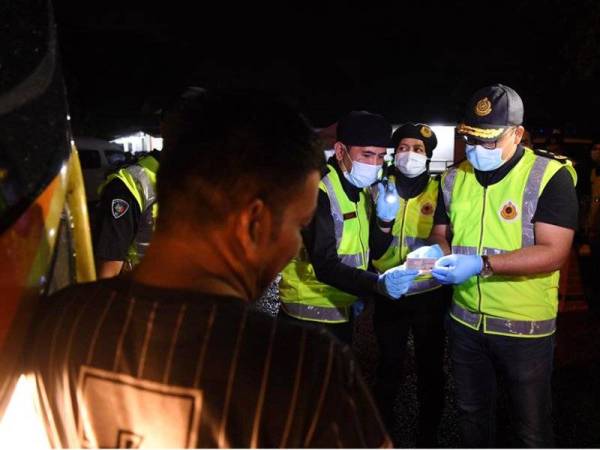 Mohd Zaki (kanan) ketika Operasi Khas Penguatkuasaan Bas Ekspres selepas Plaza Tol Gombak, Kuala Lumpur, malam tadi.