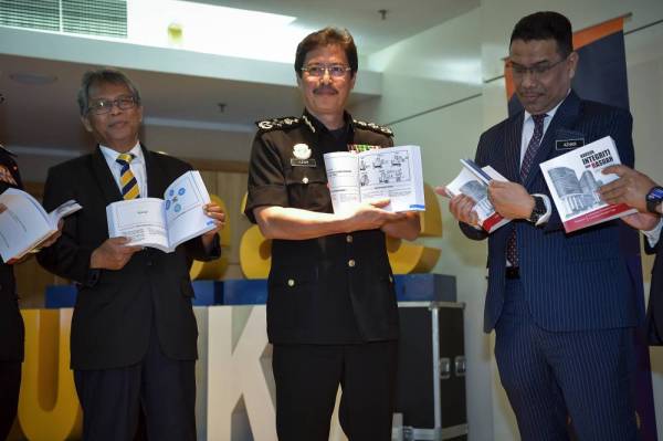 Azam Baki (tengah) menunjukkan isi kandungan buku Modul Kursus Integriti & Rasuah pada majlis pelancaran buku tersebut dan Kursus Integriti & Antirasuah di UniKL, hari ini. - Foto Bernama