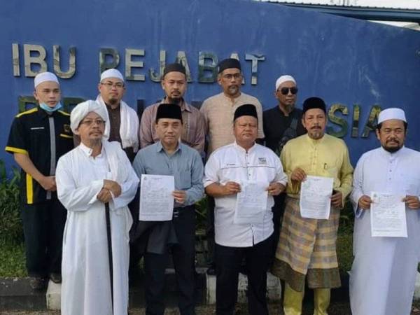 Amirudin (dua, kiri) bersama enam wakil NGO lain membuat laporan polis berhubung tindakan biadap individu yang menconteng gambar Agong dan pemimpin negara di IPD Pekan.