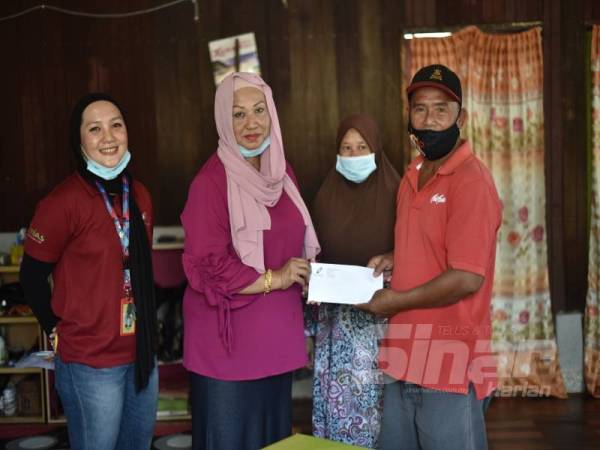 Rosniza menyerahkan sumbangan Ikhlas Prihatin kepada Muhammad Jamil. 