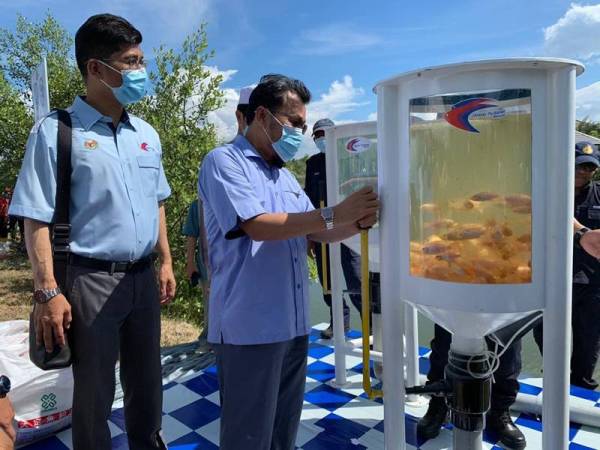 Che Abdullah menarik palang bagi melepaskan ikan ke dalam Estet Ikan Masjid Al-Rahman.