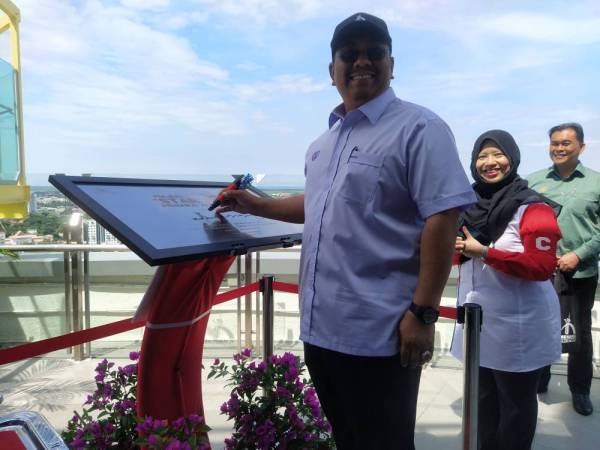 Muhammad Sanusi menandatangani plak sebagai simbolik perasmian Star View Menara Alor Setar hari ini.