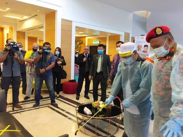 Md Anizam (dua dari kanan) turut menyertai program sanitasi di Hotel Perdana hari ini.