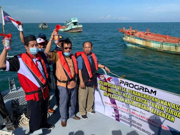 Che Abdullah (tengah) membunyikan hon untuk memberi isyarat bermulanya operasi menenggelamkan tiga buah bot yang dijadikan tukun tiruan di perairan Kuala Besar semalam.