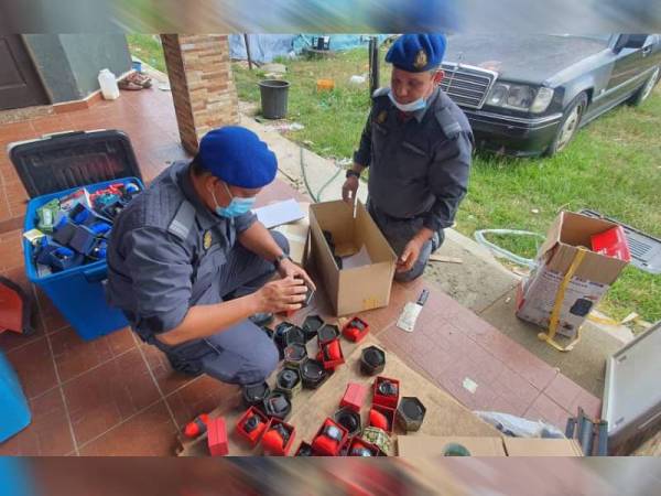 Pegawai KPDNHEP Besut memeriksa jam tangan yang dipercayai dipakaikan cap dagangan secara salah di Setiu semalam. - Foto KPDNHEP Besut