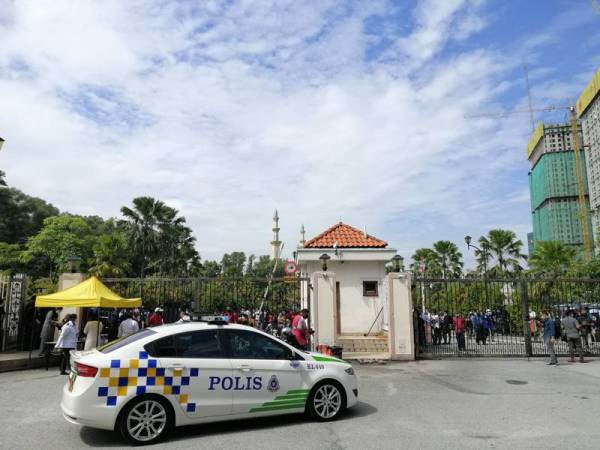 Polis memberi amaran kepada orang awam yang mengerumuni luar pekarangan mahkamah untuk mematuhi SOP Covid-19.