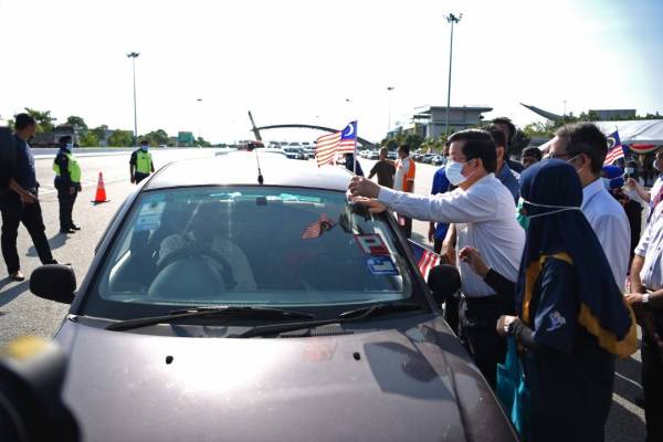 Kon Yeow memasang bendera ketika pelancaran Bulan Kebangsaan dan Kibar Jalur Gemilang Pulau Pinang 2020 di Jambatan Sultan Abdul Halim Mu'adzam Shah, hari ini.